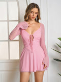 Model posing in a pink lace up mesh mini dress