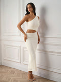 Side profile of a woman in a beige fitted maxi dress with one shoulder design