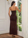 Back view of a woman in a brown sleeveless maxi dress with a flowing mesh skirt.