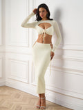 Model posing in an ivory cut out tie front knit set