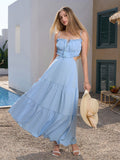 Woman posing in a flowing blue maxi dress