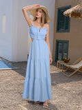 Woman in a blue tiered maxi dress and straw hat
