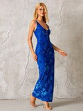 Woman posing in a fitted blue floral maxi dress