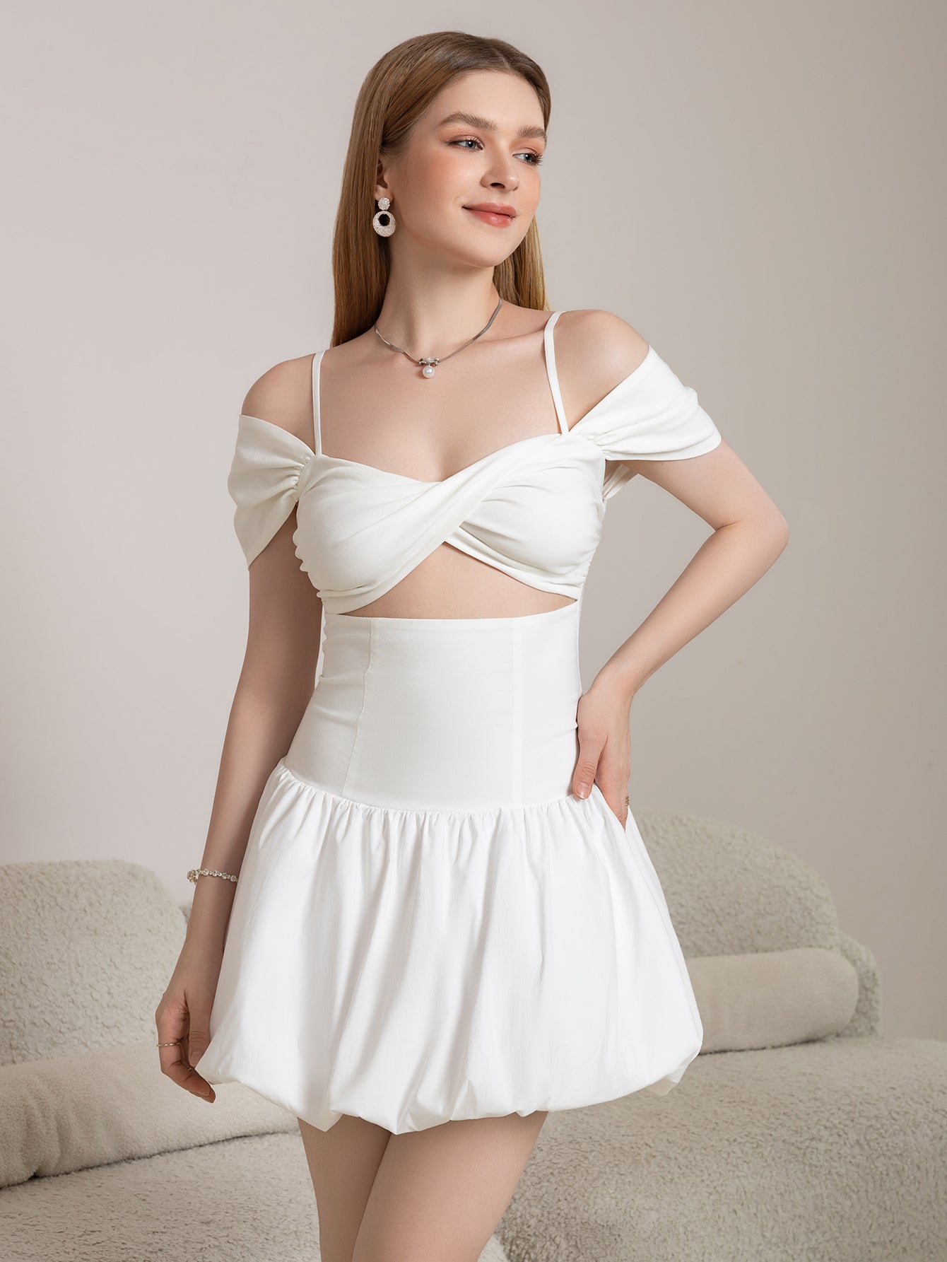 Full body shot of a woman in a white off-the-shoulder mini dress