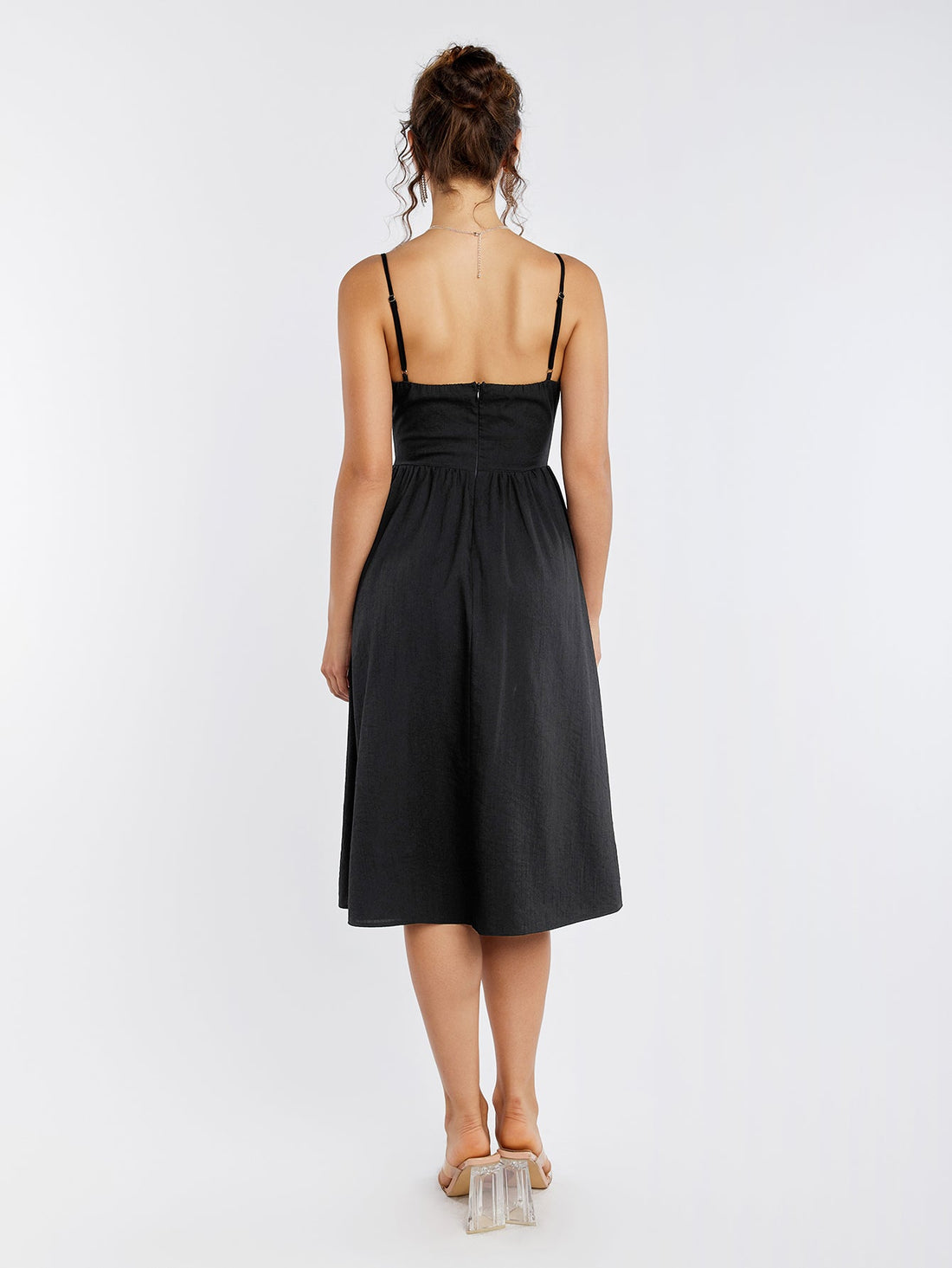 Woman wearing a black sleeveless cut out midi dress with a zipper back