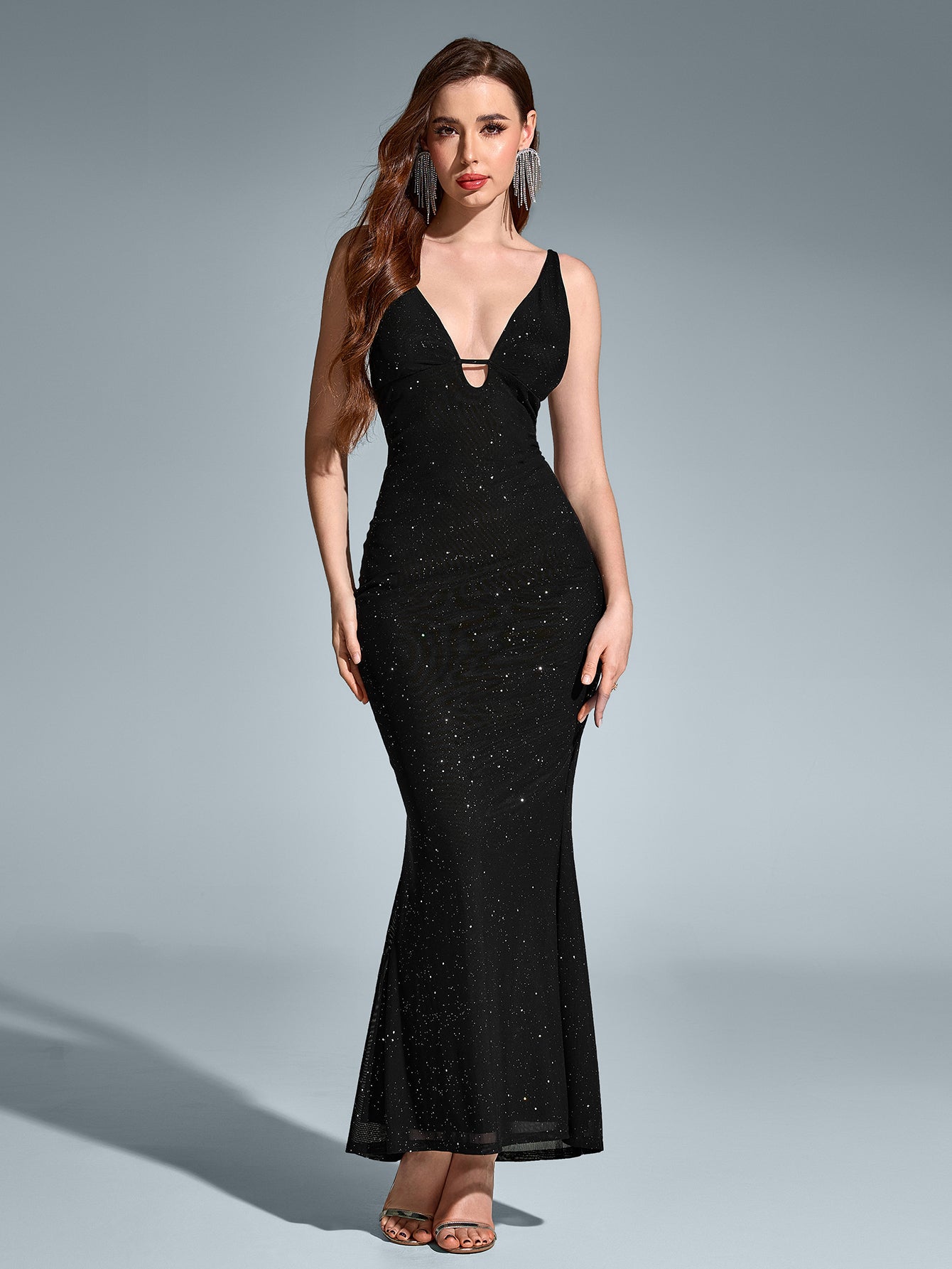 A model poses in a black V-neck sequin mermaid dress