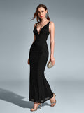 Woman holding a clutch and walking in a black sequin mermaid maxi dress