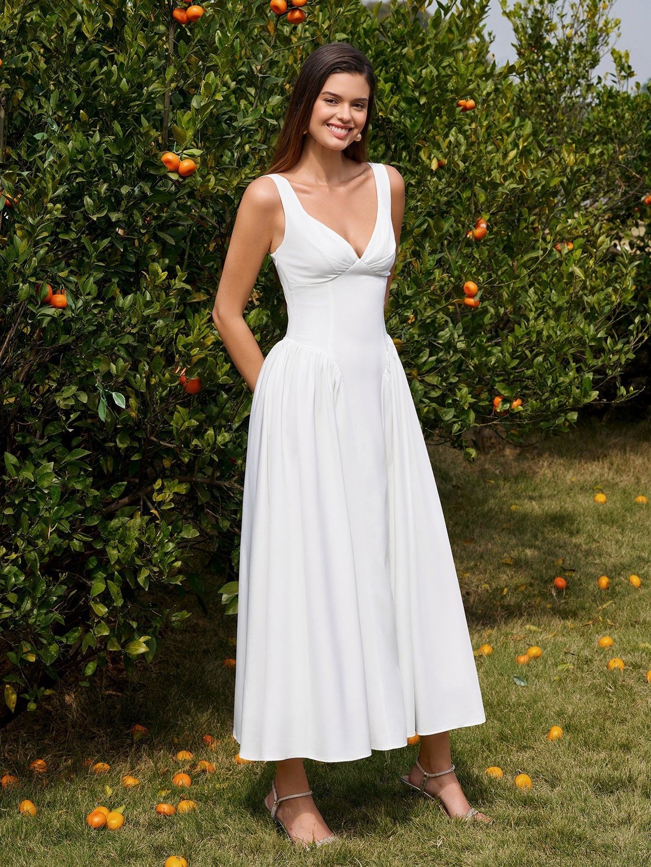 Model posing in white ruched corset midi dress