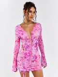 Model posing in a pink floral print mini dress with long flounce sleeves