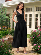 Woman posing in a black V-neck ruched midi dress in a garden setting.