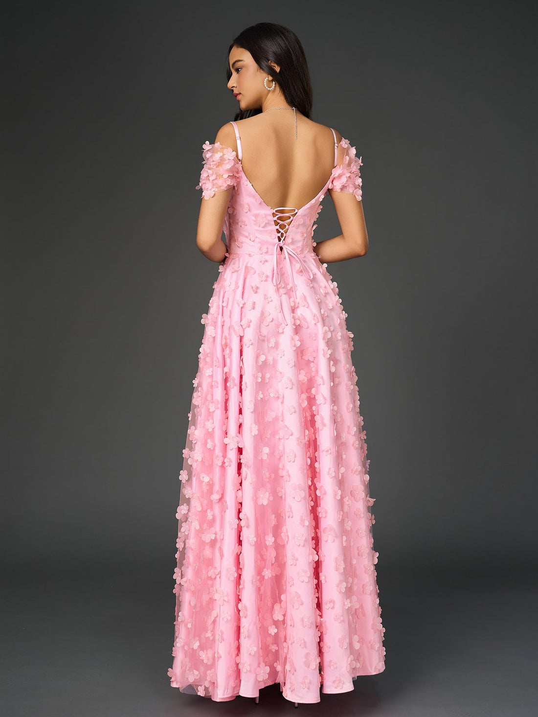 Woman wearing a pink floral applique V-neck maxi dress with off-the-shoulder sleeves