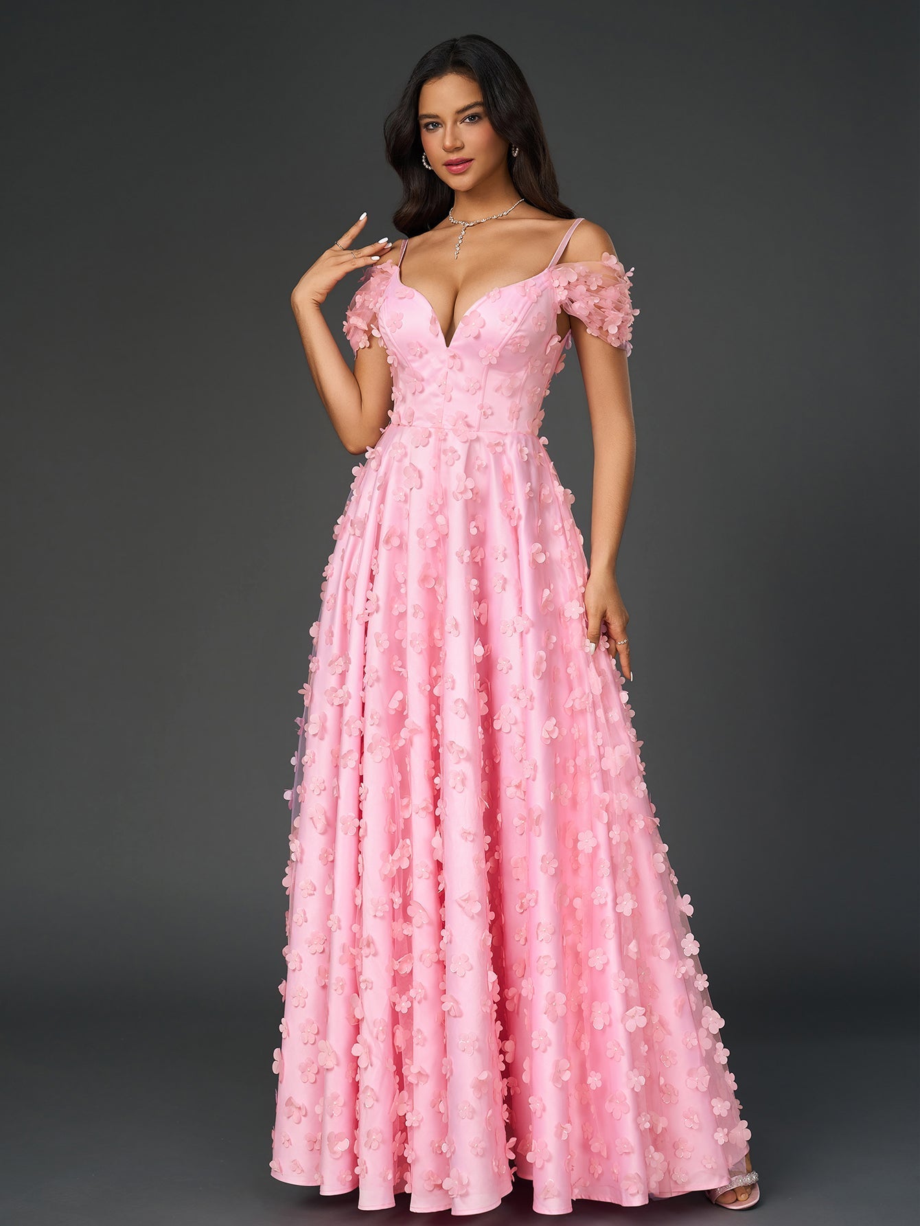 Woman wearing a pink floral applique V-neck maxi dress with off-the-shoulder sleeves