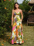 Woman wearing a green floral print maxi dress with a V-neckline and crisscross back
