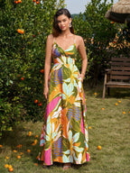 Woman wearing a green floral print maxi dress with a V-neckline and crisscross back