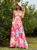 Woman in a straw hat wearing a pink floral print maxi dress outdoors