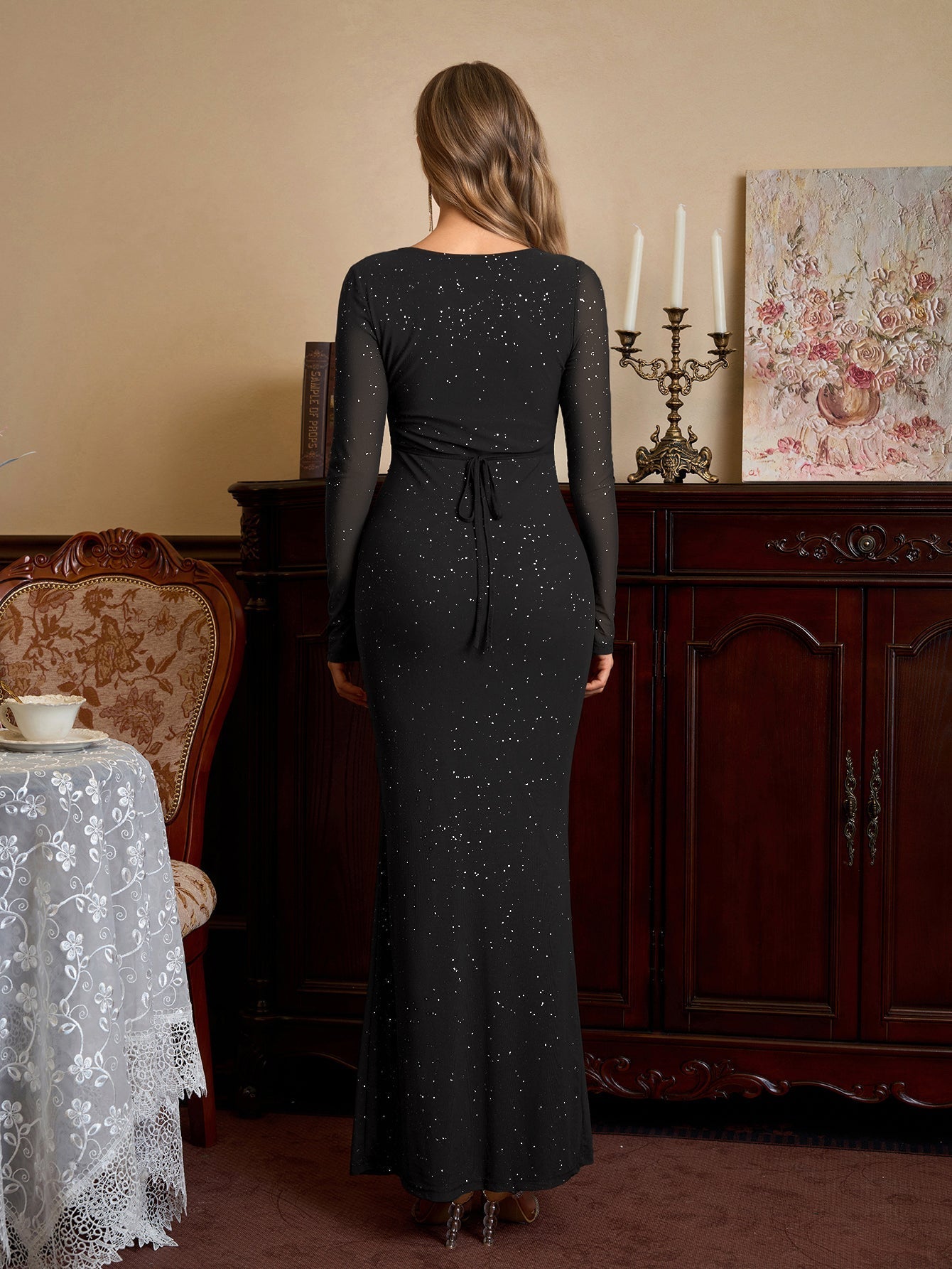 Back view of a black glitter maxi dress with a tie back detail