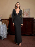 Woman wearing a black glitter maxi dress with a deep V-neck and crisscross tie front