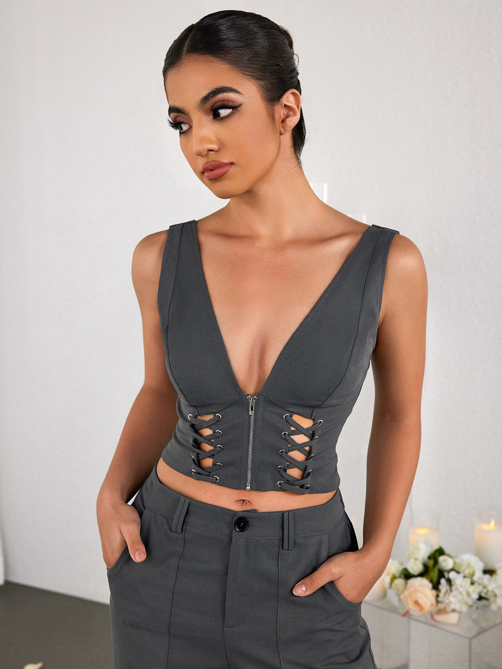Model posing in a grey V-neck crop top and matching trousers