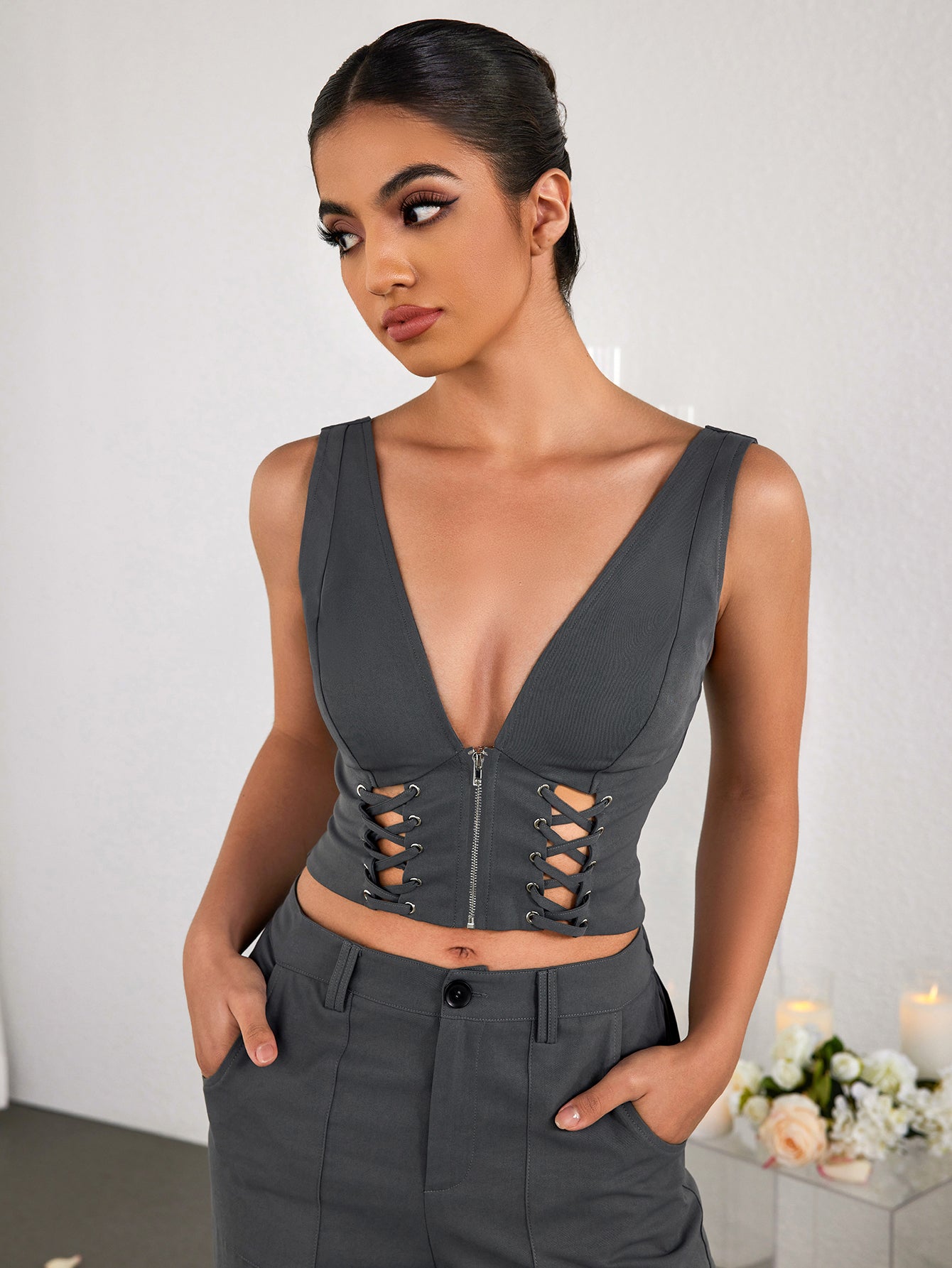 Model posing in a grey V-neck crop top and matching trousers