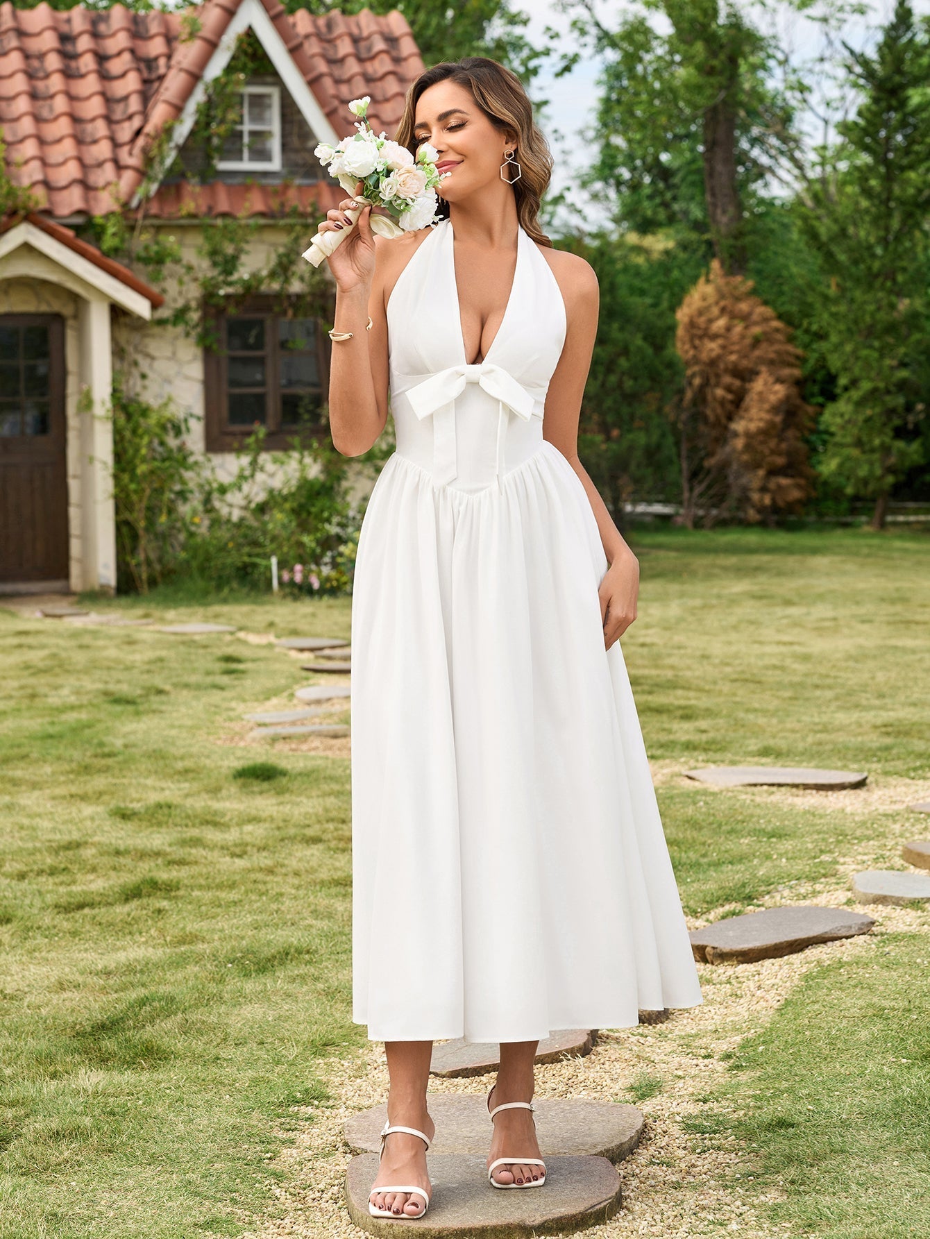 Close-up of the bow detail on a white halter neck maxi dress
