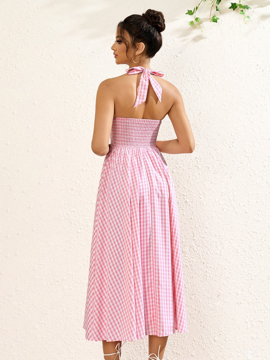 Woman wearing a pink plaid halter neck midi dress