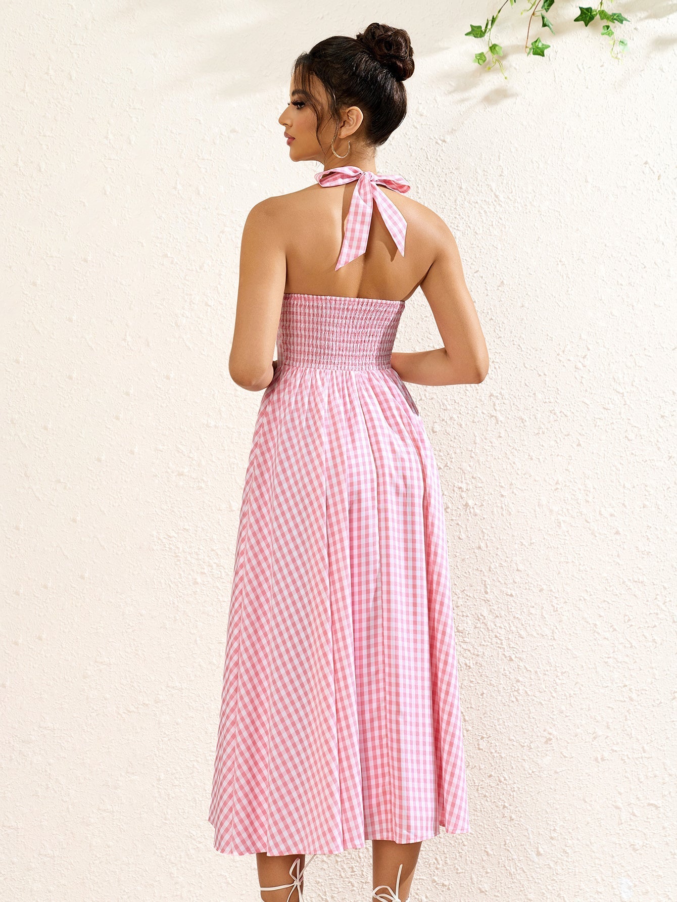 Back view of a pink plaid halter neck midi dress