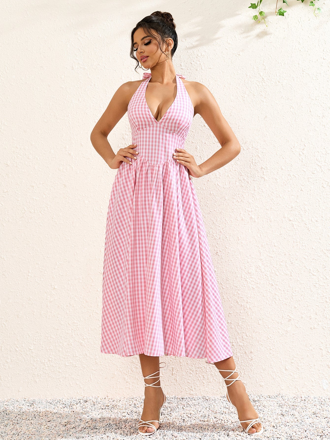 Full body shot of a pink plaid halter neck midi dress