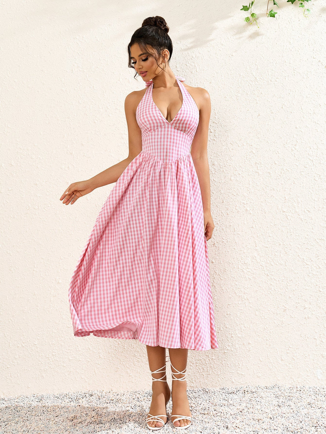 Woman wearing a pink plaid halter neck midi dress