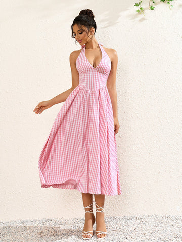 Woman wearing a pink plaid halter neck midi dress