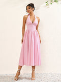 Close-up of the fabric pattern on a pink plaid halter neck midi dress