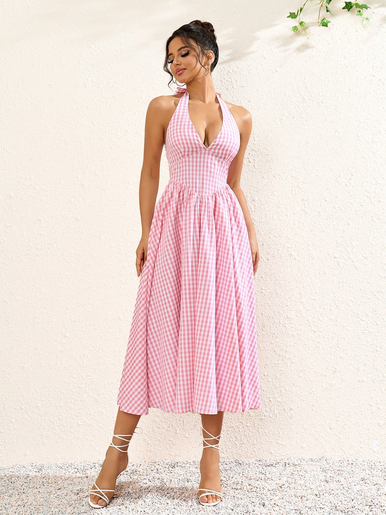 Close-up of the fabric pattern on a pink plaid halter neck midi dress