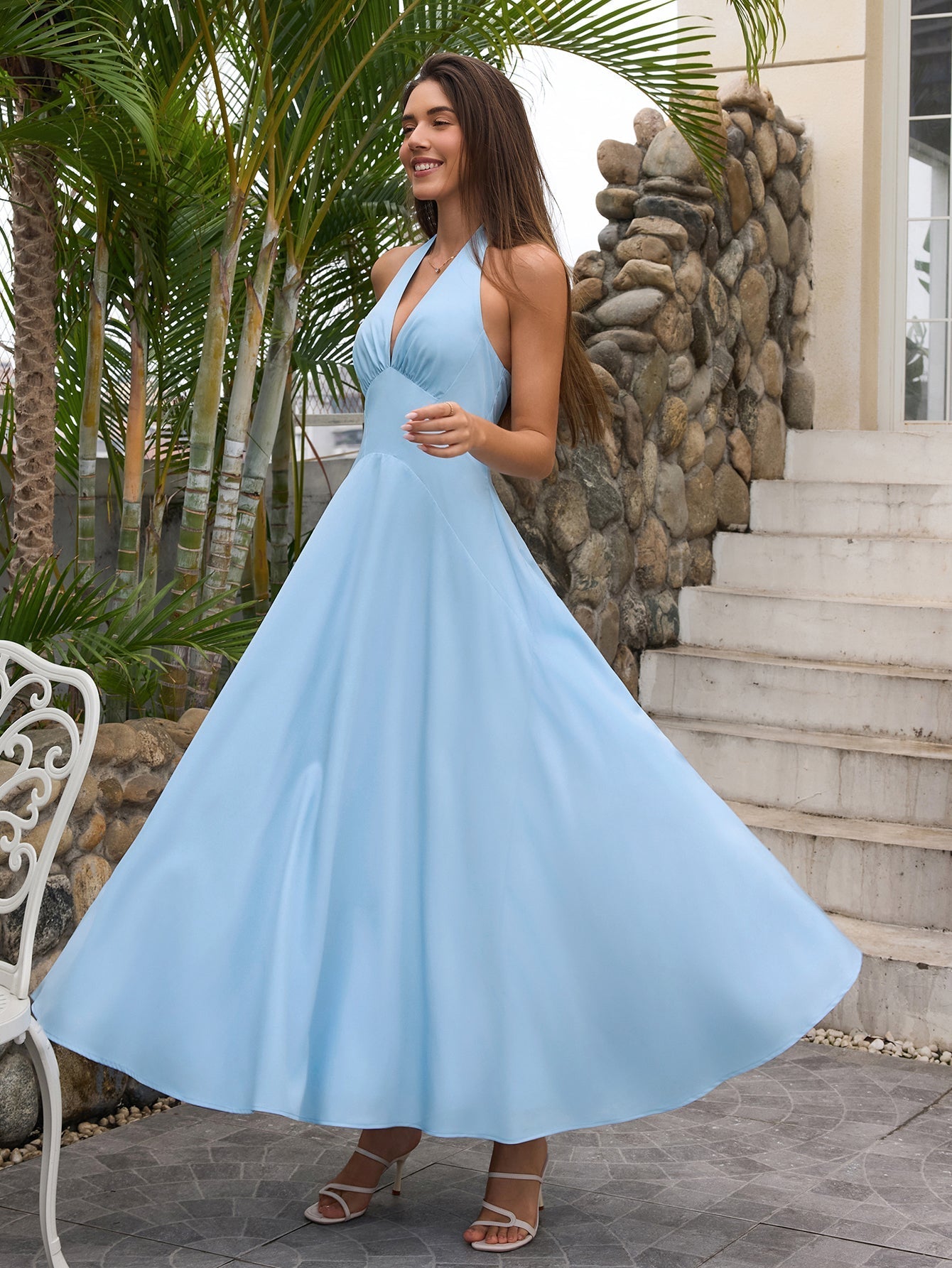 Woman twirling in a blue halter neck A-line maxi dress