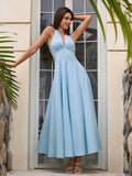 Model posing in a flowy light blue halter neck maxi dress