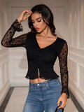 Close-up of the ruched detail on a black V-neck crop top