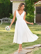 Close-up of the V-neckline and button details on a white maxi dress