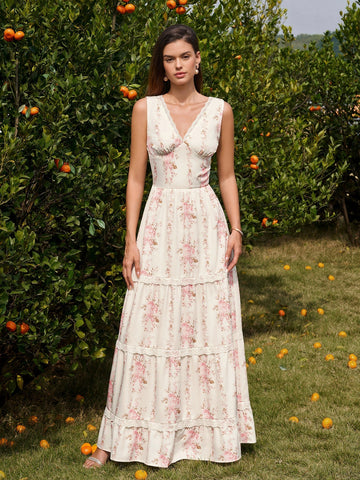 Woman wearing a cream floral print maxi dress with pink flowers and lace trim