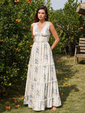 Woman wearing a cream floral print maxi dress with blue flowers and lace trim