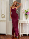 Woman posing in a burgundy ruched maxi dress with a high slit and V-neck