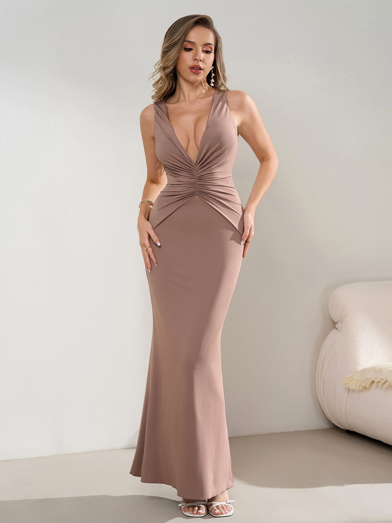 Full length shot of a woman in a taupe V-neck ruched maxi dress