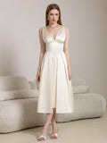 Woman wearing a beige satin midi dress with a V-neckline and A-line skirt