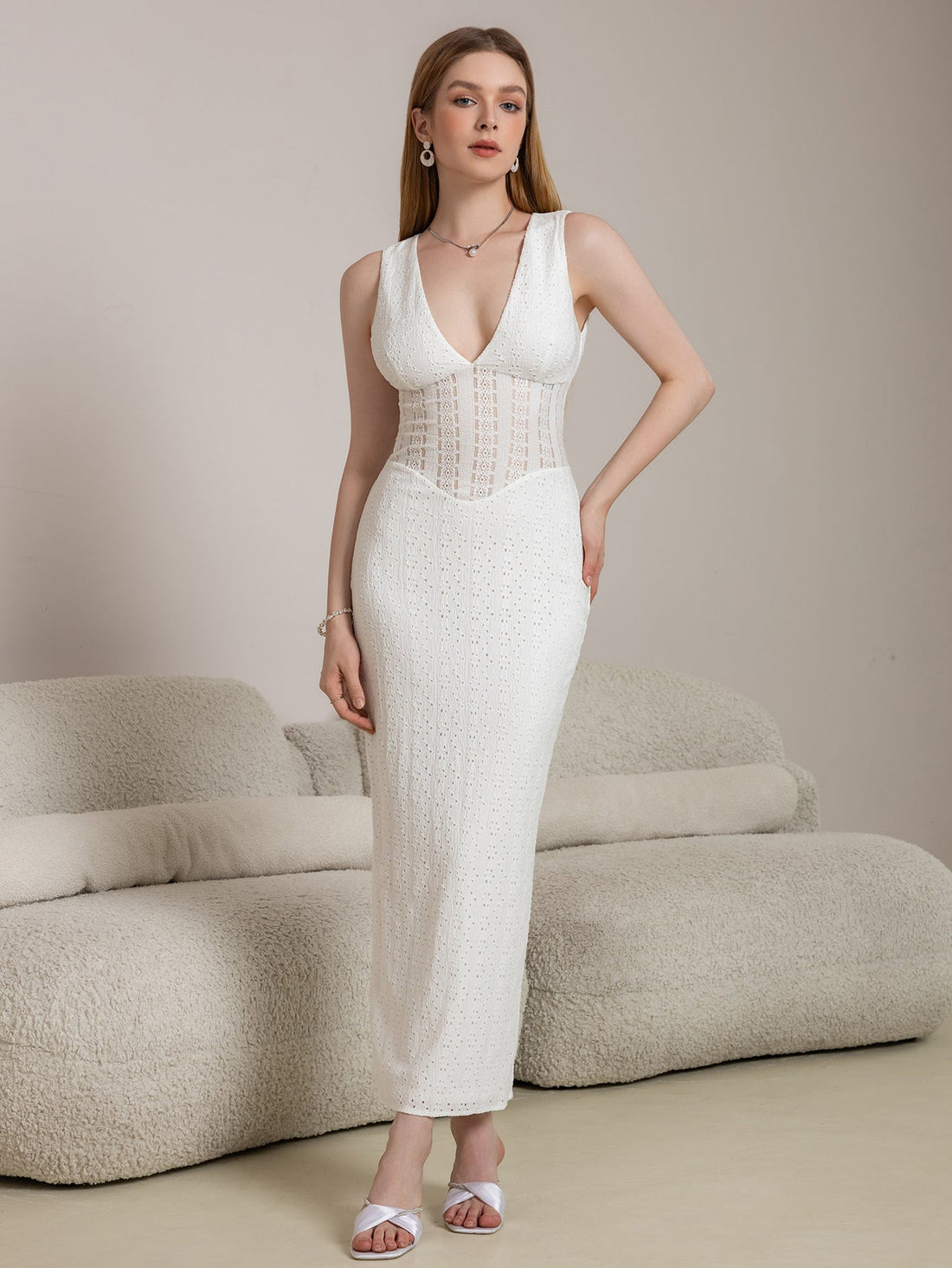 Woman wearing a white sleeveless V-neck maxi lace dress with jacquard bodice