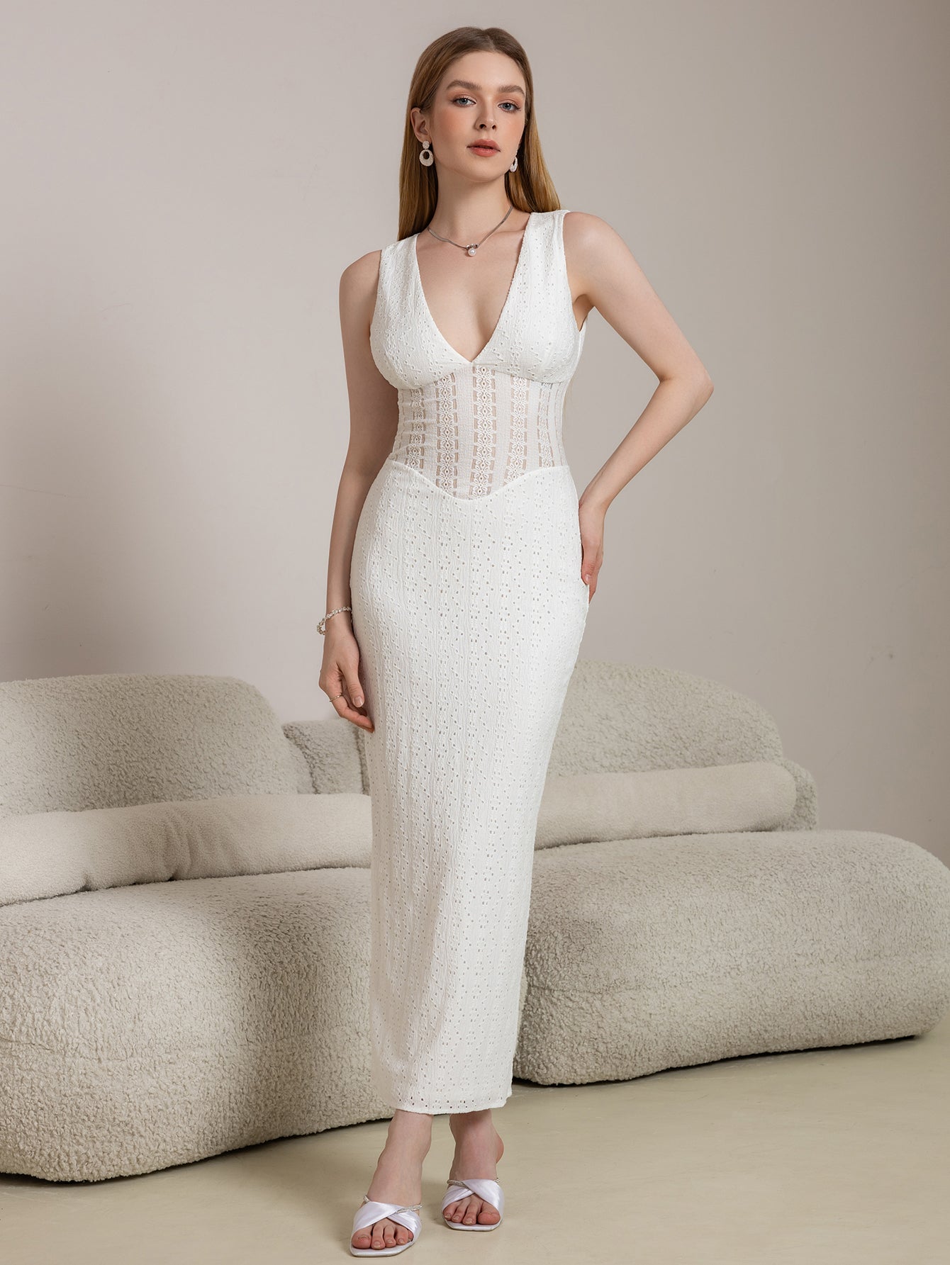 Woman wearing a white sleeveless V-neck maxi lace dress with jacquard bodice