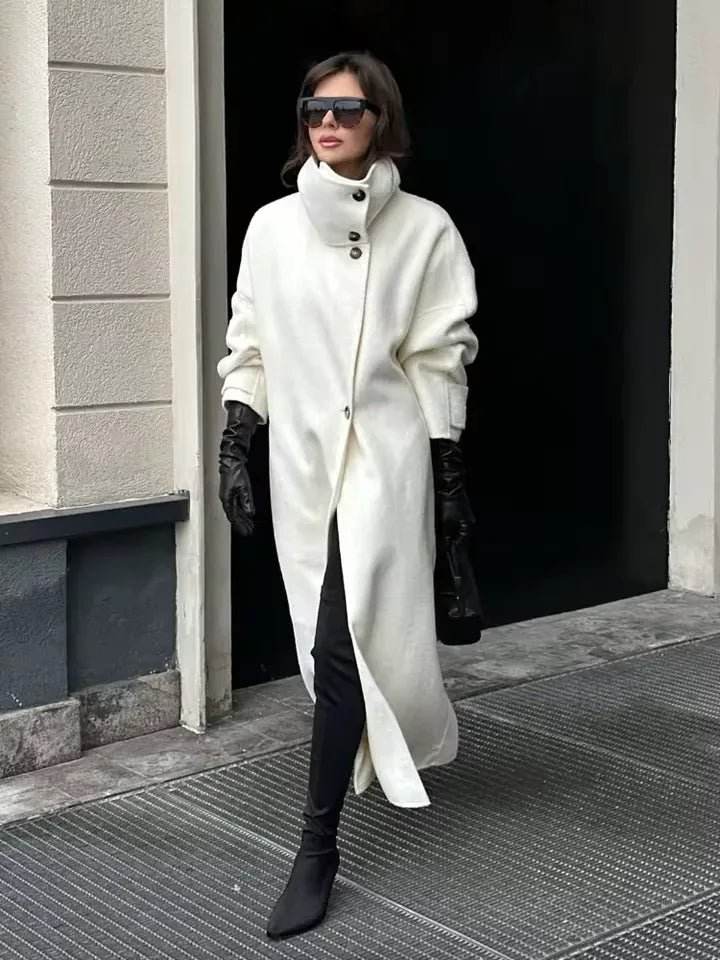 Woman wearing a white wool blend funnel neck long coat with black gloves and sunglasses