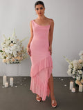 Woman wearing a pink mesh maxi dress with draped neckline and ruffle hem