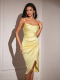 Full shot of a woman in a chic yellow satin cami dress with asymmetrical hem