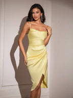 Full shot of a woman in a chic yellow satin cami dress with asymmetrical hem