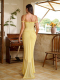 Back view of a woman in a yellow ruched asymmetrical hem mesh maxi dress