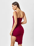 Back view of a woman in a red embellished ruched midi dress, showing the zipper closure and spaghetti straps.