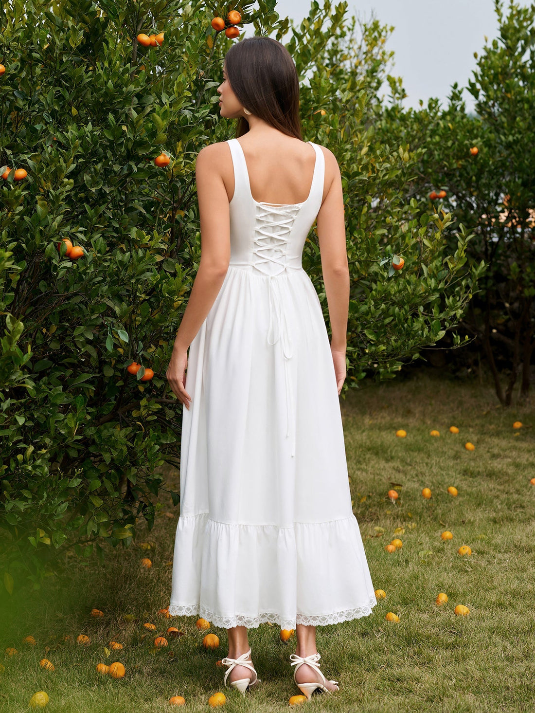 Woman wearing a white embellished button maxi dress with lace trim