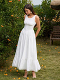 Woman posing in a white fitted bodice maxi dress outdoors